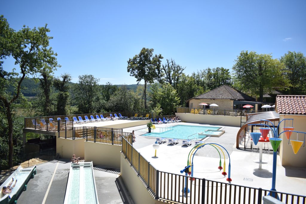 parc aquatique avec aire de jeux aquatique, piscines chauffées et couverte dominé par ses toboggans en bordure de la rivière Dordogne dans le Périgord noir